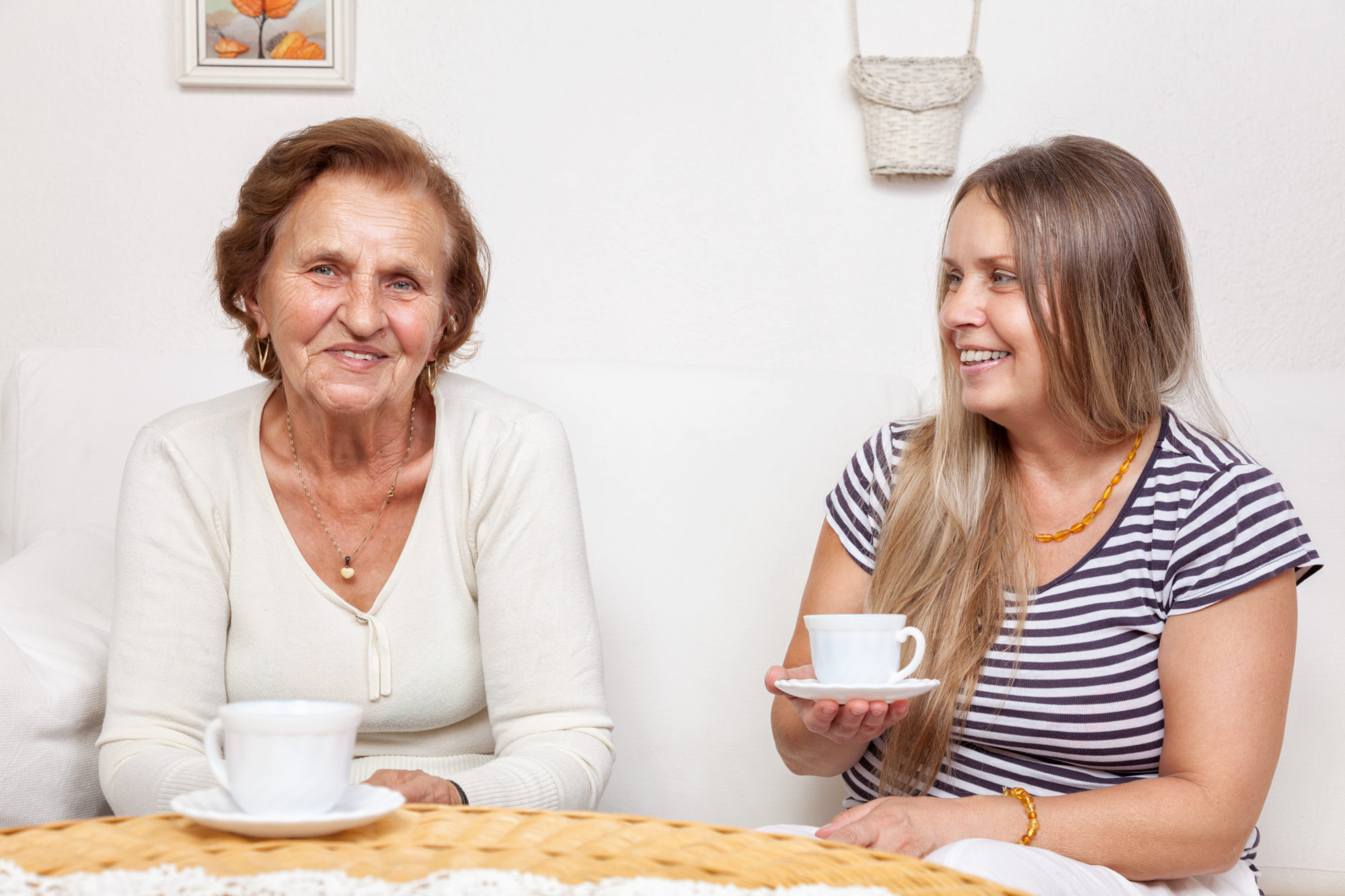 Carer having a cup of tea with an elderly retired woman