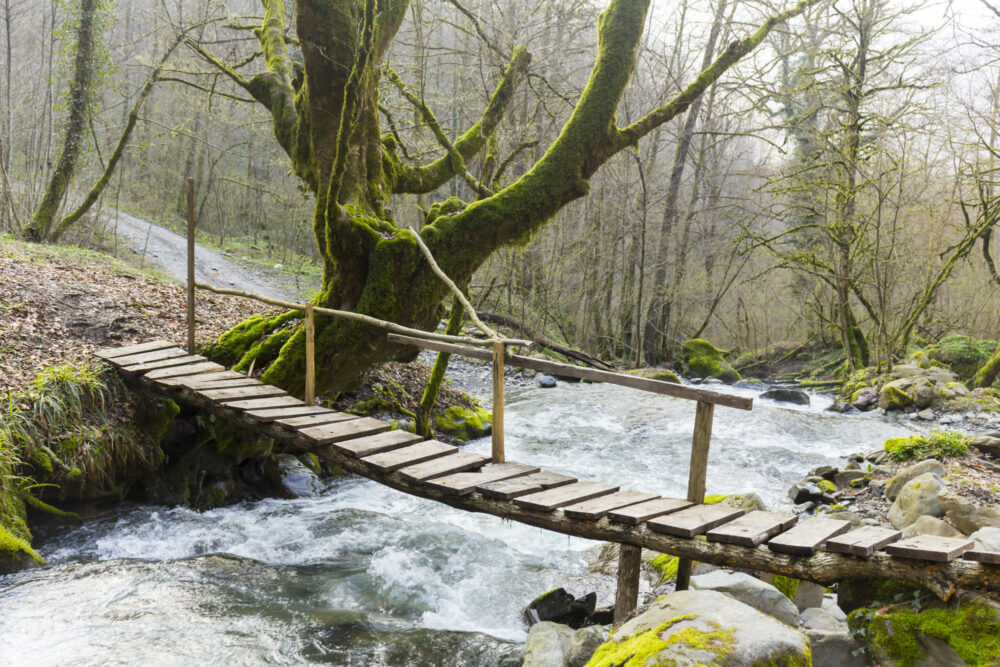 Small wooden bridge over the mountain rive