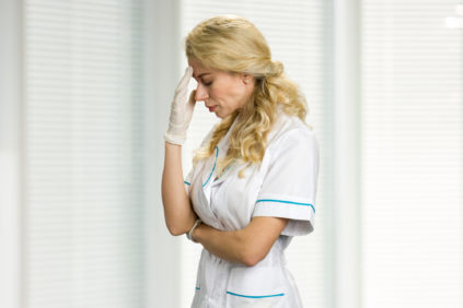 Portrait of young nurse with headache.