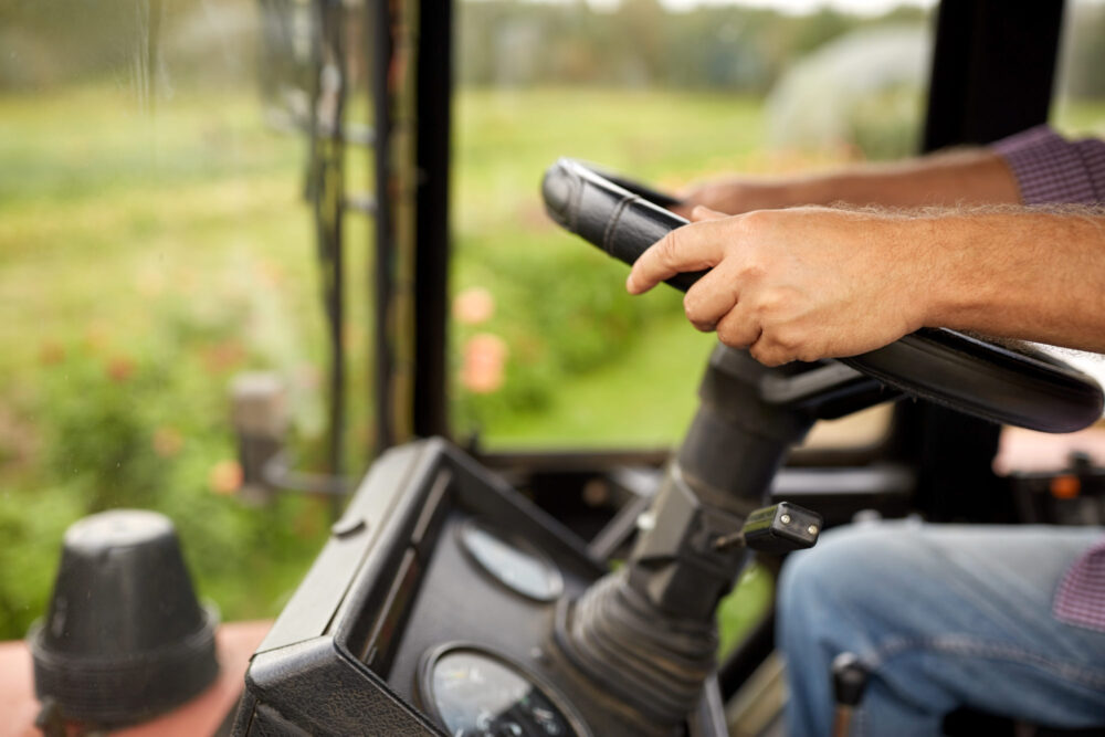 senior man driving tractor at farm