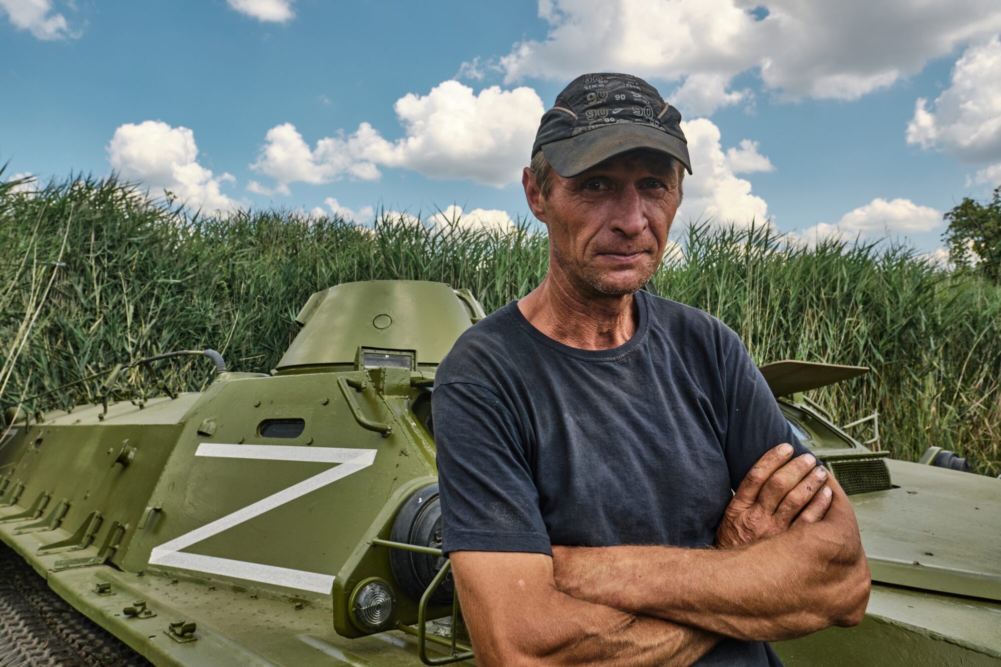 Ukrainsk bonde foran en russisk trofétank i Kharkiv-regionen, Ukraina.